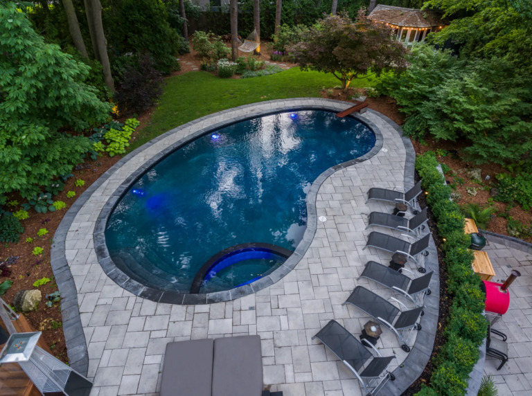 Backyard of a modern villa with a pool and 1980s architectural features.