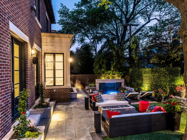 Elegant backyard design showcasing a stone patio and green landscaping.