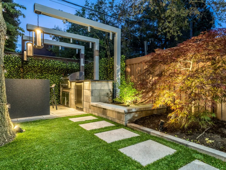 Stylish outdoor space with stone pathway, garden features, and modern lighting.