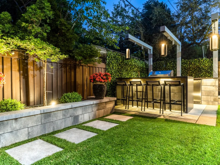 Contemporary outdoor space featuring stone steps, garden beds, and accent lighting.
