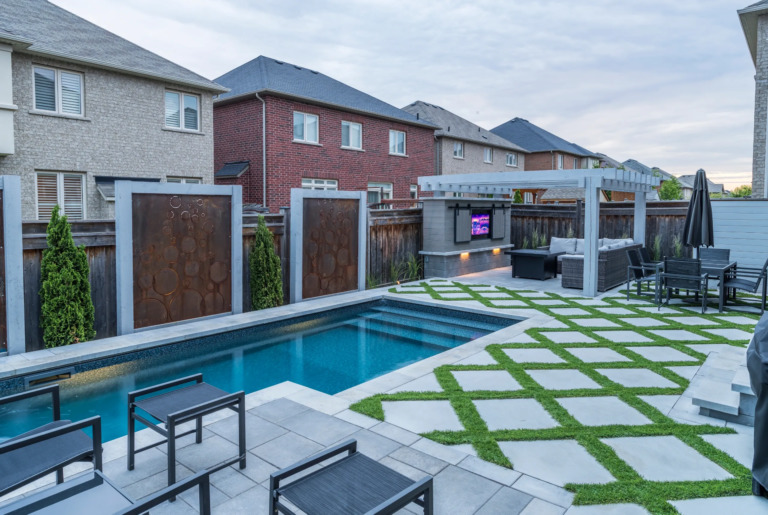 Luxurious backyard with a pool, greenery, and outdoor seating.
