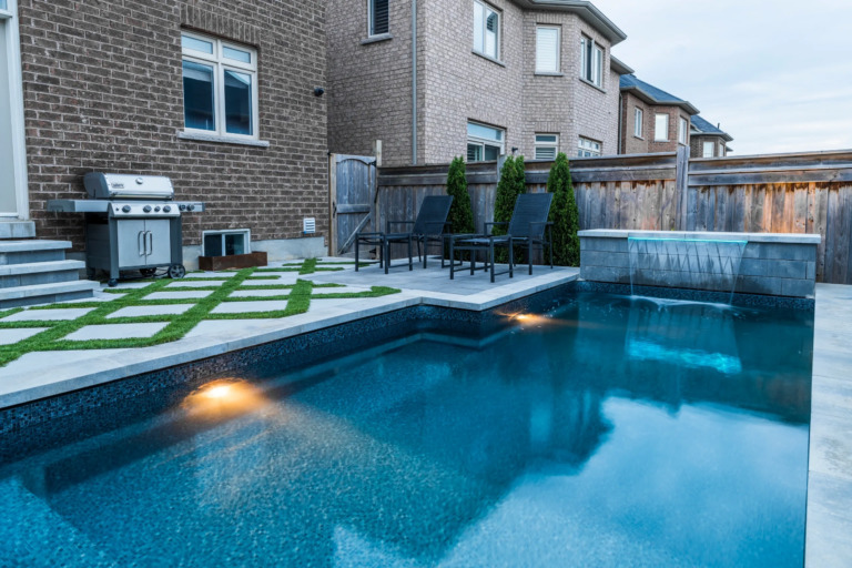 Aerial view of a residential outdoor area with a pool and lush garden.