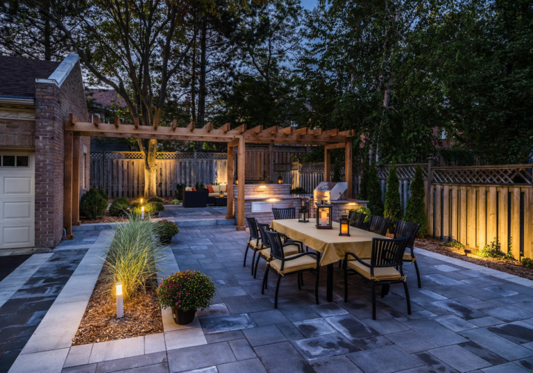 Sophisticated backyard with a wooden deck, contemporary furniture, and green lawn.