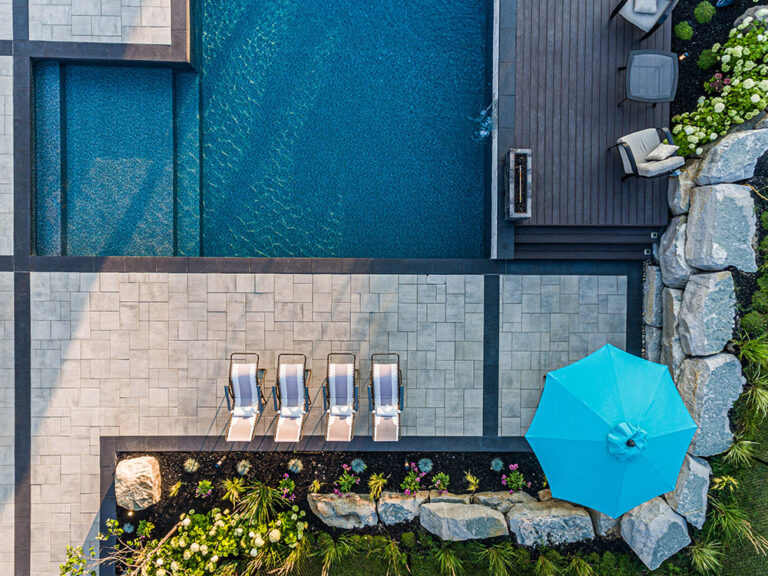 Aerial view of a backyard showcasing a luxurious pool and greenery.