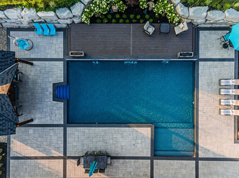 Aerial shot of a modern home with a landscaped garden and swimming pool.