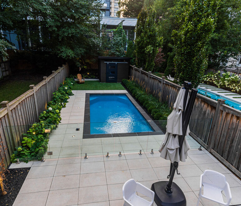 Aerial view of a luxury home with a landscaped yard and swimming pool.