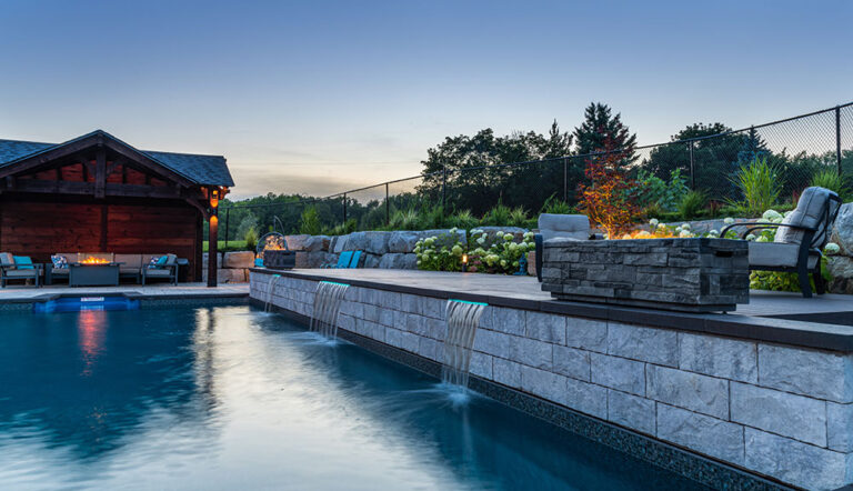 Wide-angle view of a contemporary backyard with a luxurious pool and outdoor seating.
