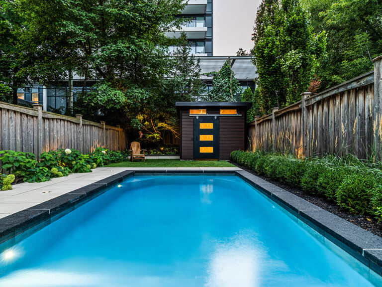 Outdoor seating area by the pool with modern furniture and lush landscaping.