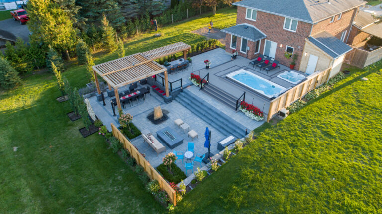 Wide aerial view showcasing a large modern pool and landscaped garden.