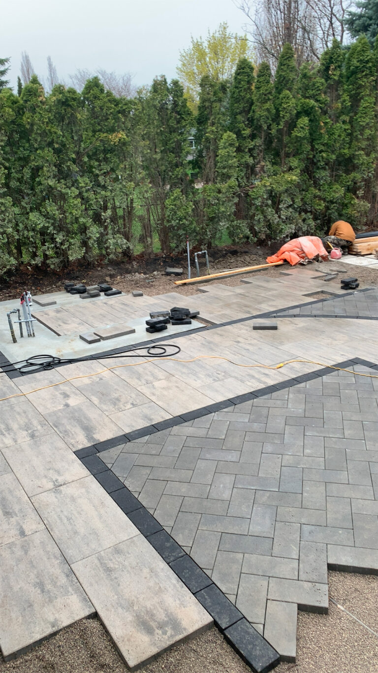 Deer Chase backyard - stone pathway leading to a contemporary patio area with seating and greenery.