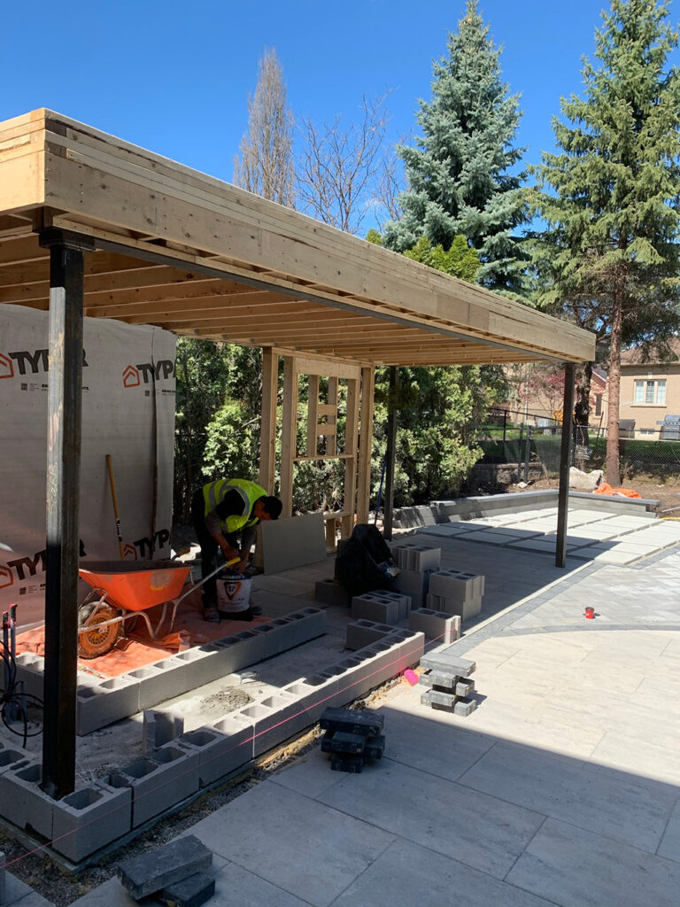 Deer Chase backyard - evening view of modern pool and illuminated landscaping features.