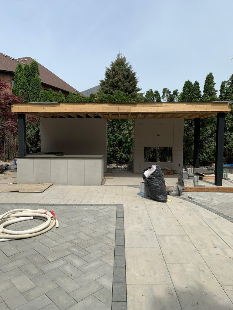 Deer Chase backyard - close-up of pool area with stone patio and surrounding greenery.