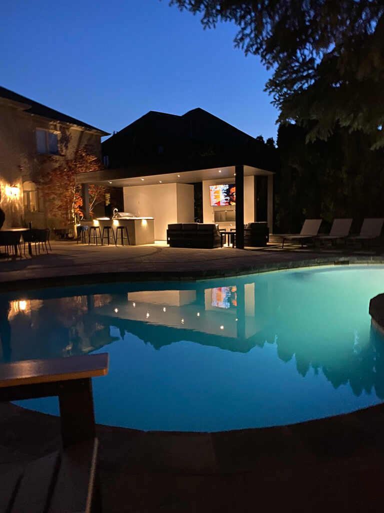 Luxury backyard pool with stylish stonework and manicured garden.