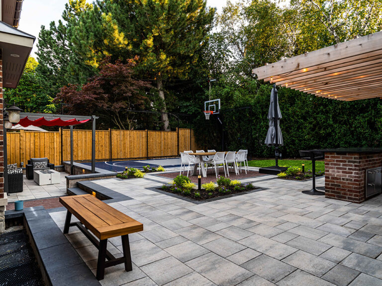 Sophisticated backyard with a pool, stylish seating, and green surroundings.