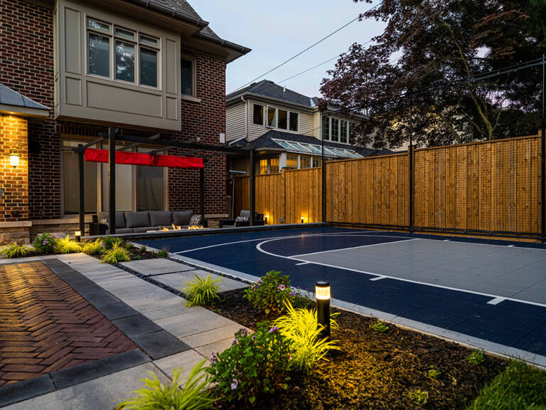 Backyard pool area featuring modern outdoor furniture and lush greenery.