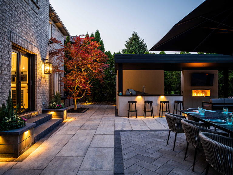Beautifully landscaped backyard with modern patio and seating area surrounded by greenery.