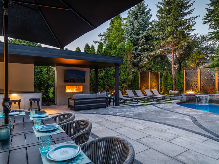 Modern outdoor dining area with stylish furniture in a beautifully landscaped yard.