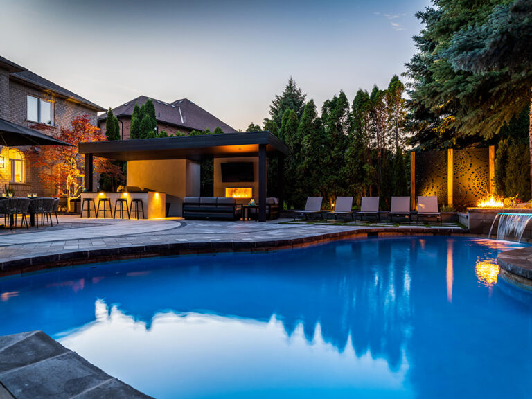 Backyard with a stone patio, firepit, and surrounding plants for a relaxed outdoor space.