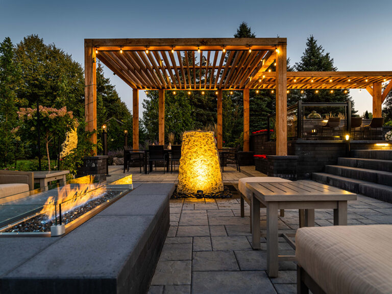 Beautifully designed backyard pool surrounded by modern landscape and stonework.