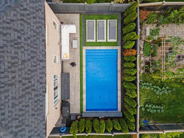 Contemporary backyard featuring a mix of lawn and hardscaping