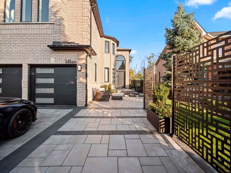 Luxurious backyard featuring a green lawn and stone patio
