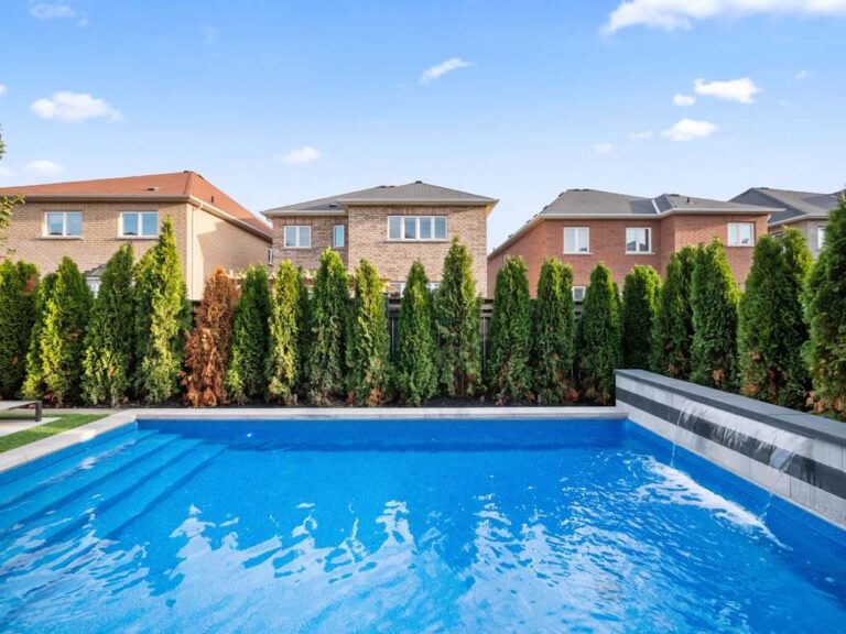 Backyard featuring a modern pool and lounge chairs