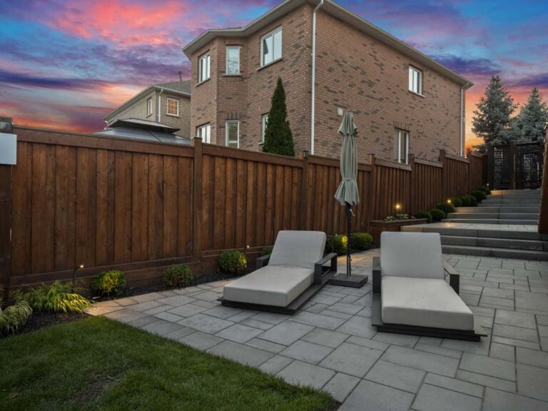 Elegant backyard with a stone patio and green lawn