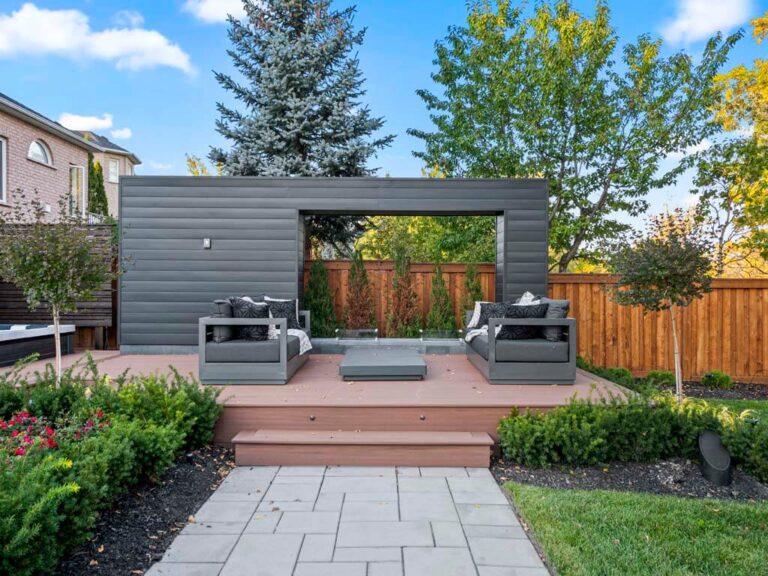 Backyard with a mix of lawn, stone, and outdoor furniture