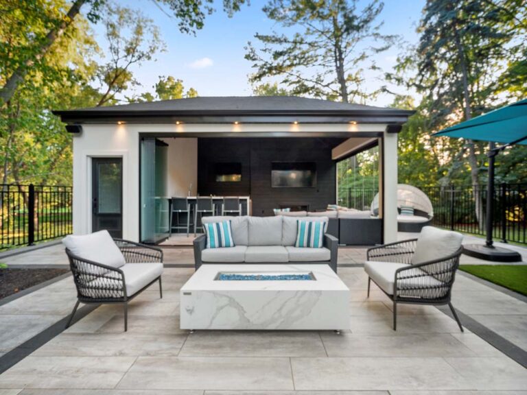 Luxurious backyard with a large pool, deck, and stylish furniture