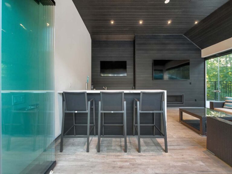 Beautifully landscaped backyard with a pool, trees, and outdoor lighting