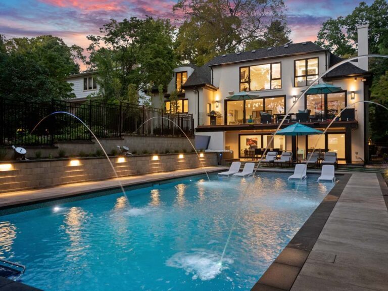 Charming backyard with a small pool, lush plants, and comfortable seating