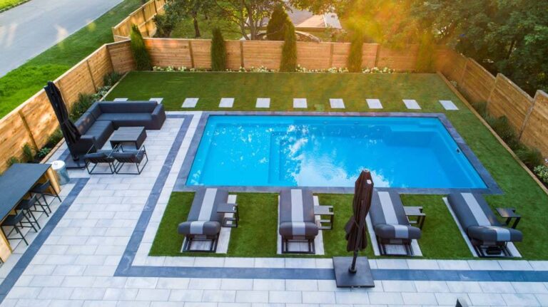 Aerial view of a well-designed backyard with a pool and garden