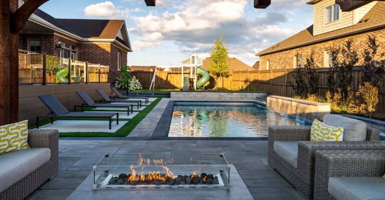 Modern backyard with a large patio space, seating area, and ornamental plants