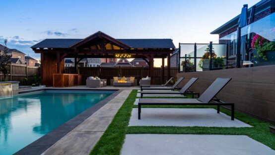 Beautifully landscaped backyard with a modern stone patio and lush greenery