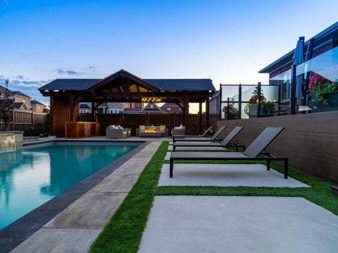 Beautifully landscaped backyard with a modern stone patio and lush greenery