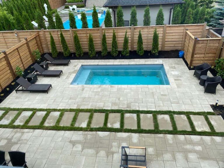 Backyard setup with stone patio, seating, and landscaped garden