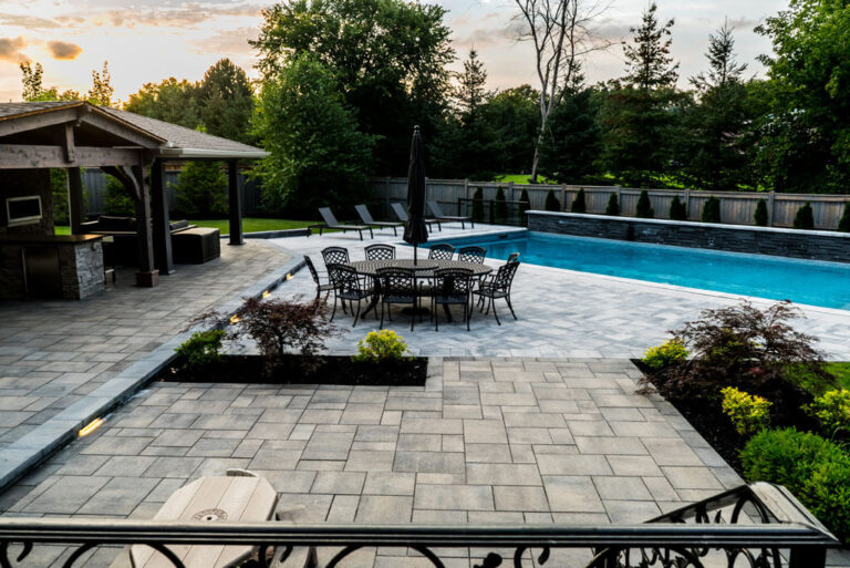 Backyard with green lawn, stone pathways, and decorative plants