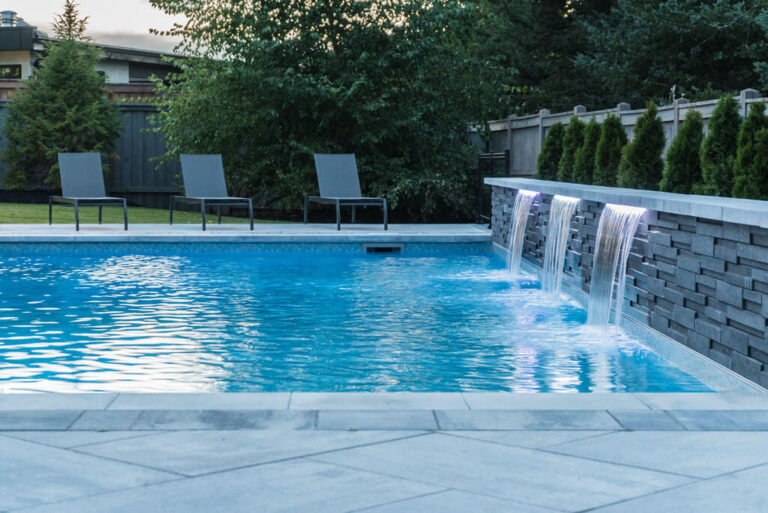 Stone walkway leading to a modern backyard with seating area