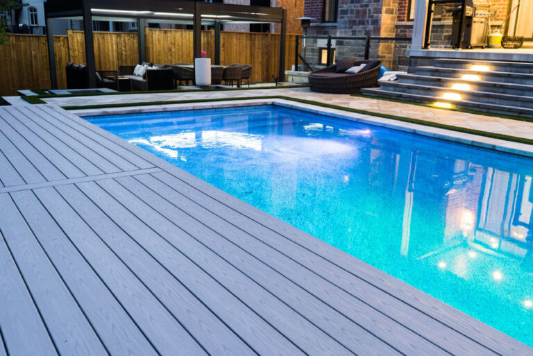 Stone patio with comfortable lounge chairs by the pool