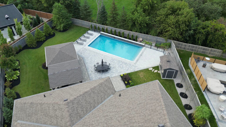Elegant backyard patio with outdoor dining set and green lawn