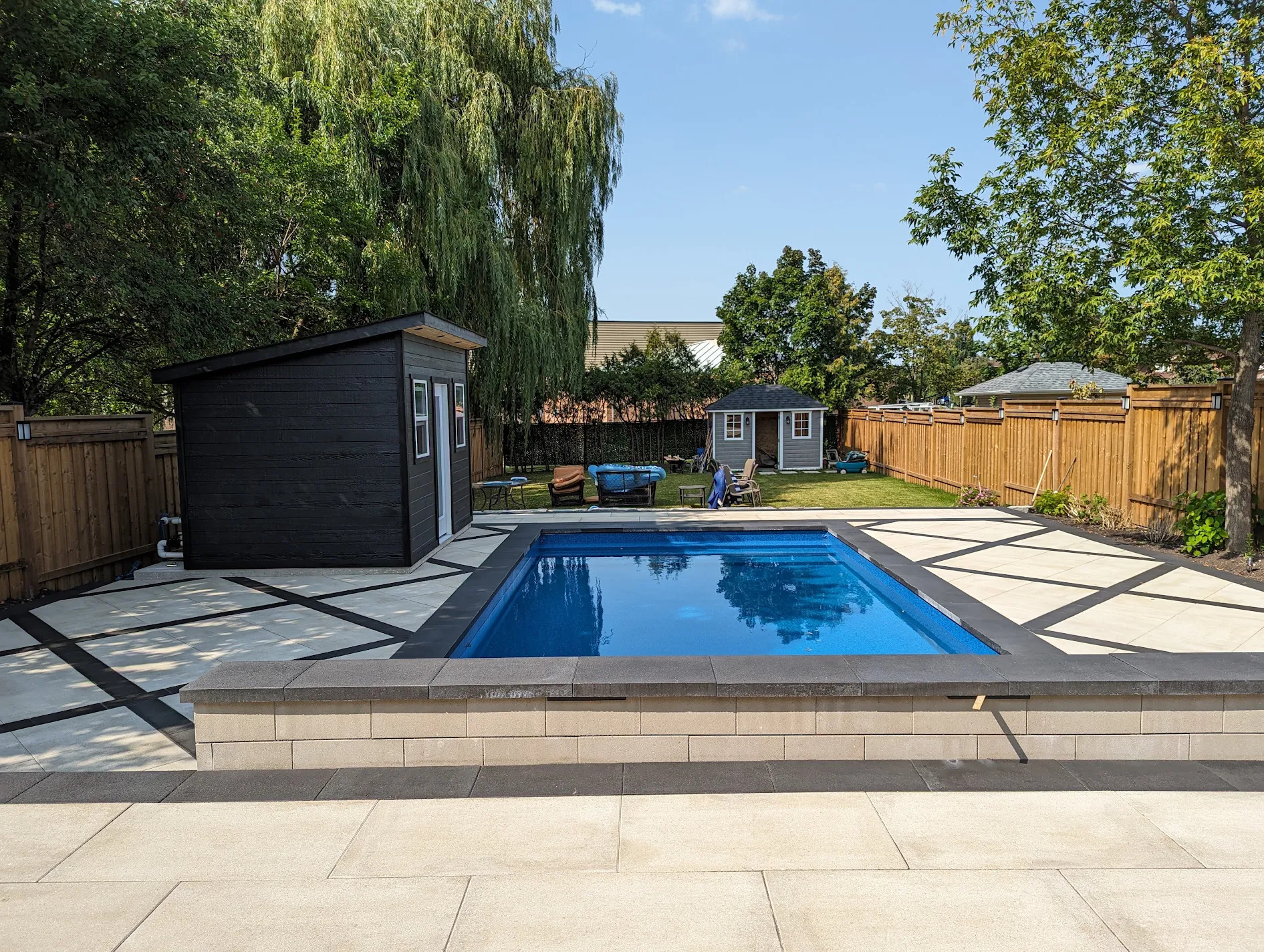 Inground pool with modern black cabana built by Land-Con in Toronto